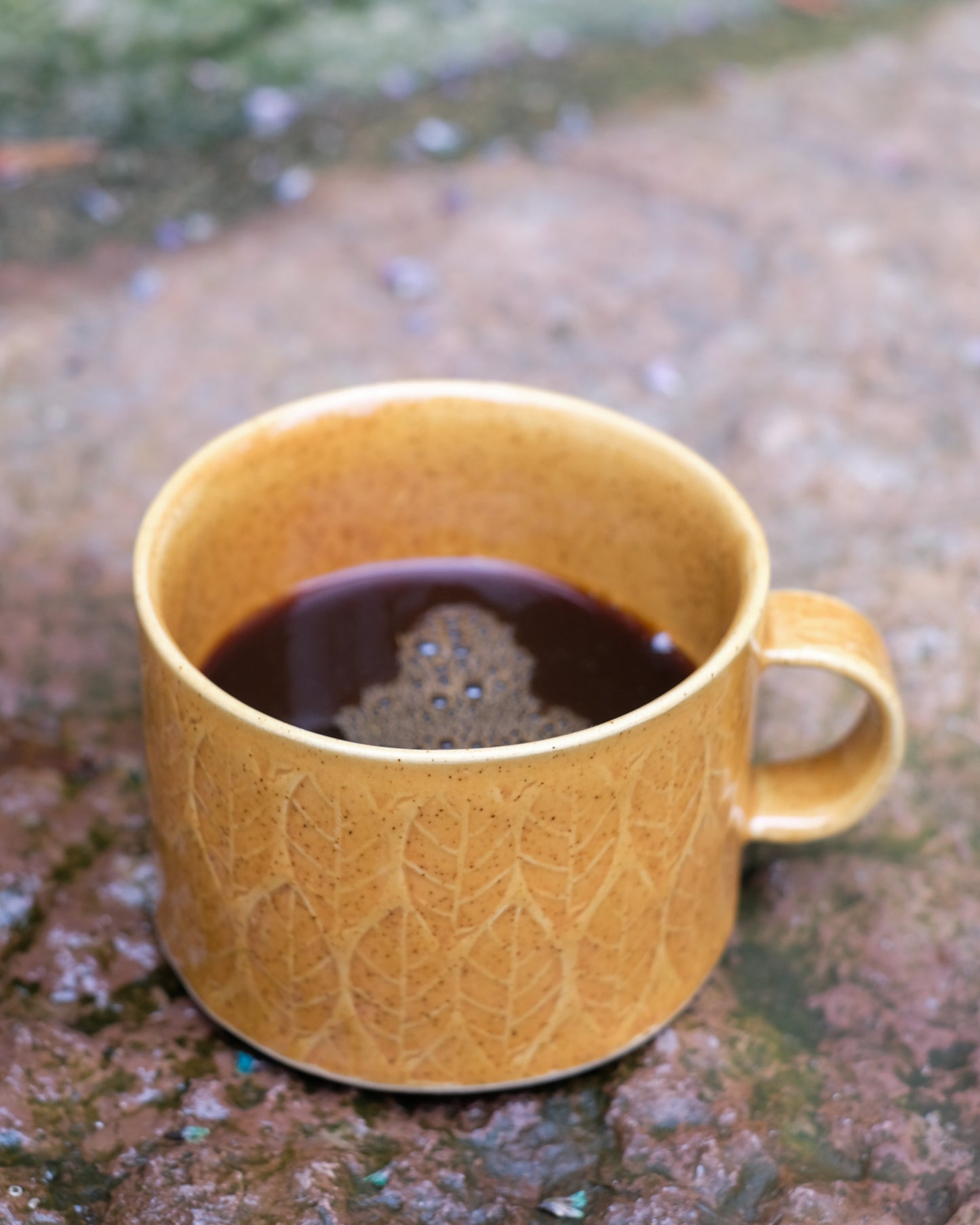 Kavlad kopp med lövmönster senapsgul med prickar