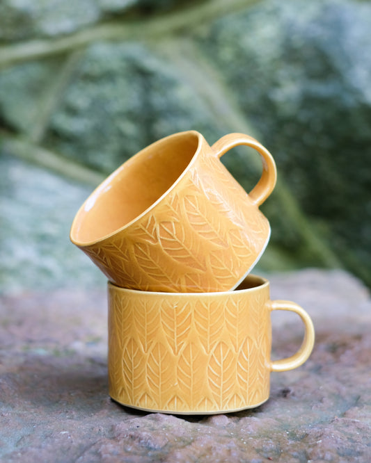 Kavlad kopp med lövmönster senapsgul