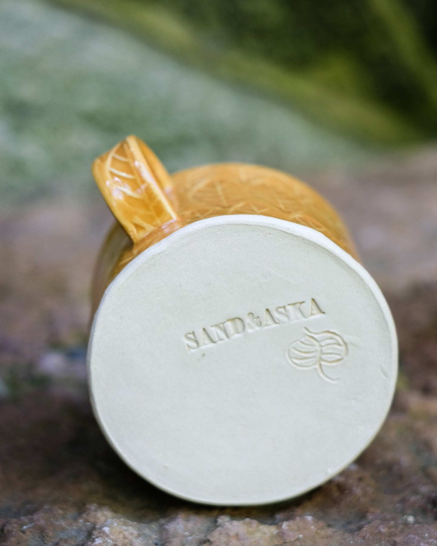 Kavlad kopp med lövmönster senapsgul