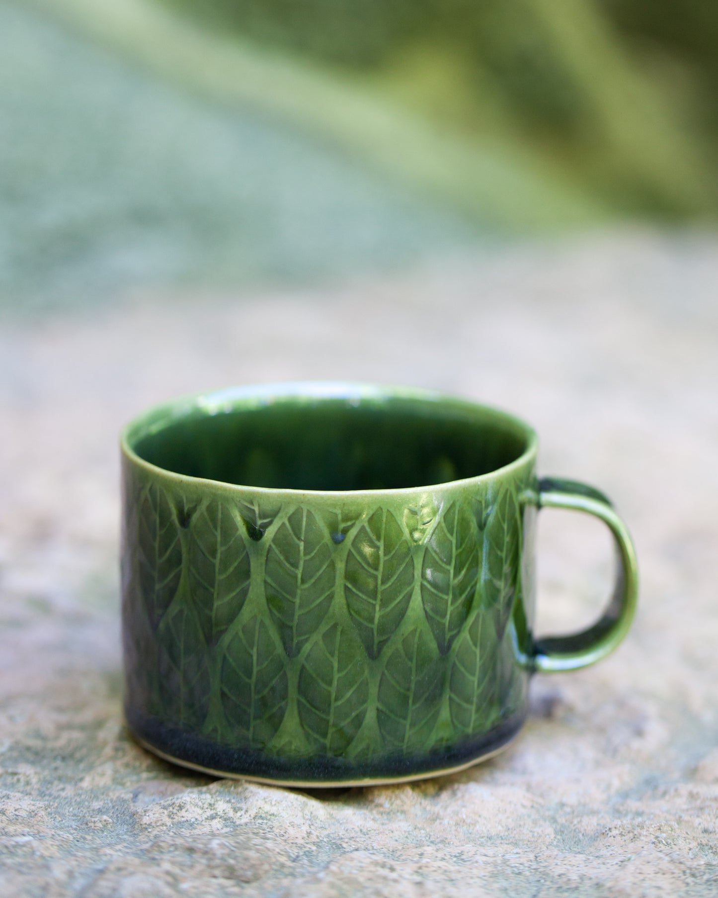 Kavlad kopp med lövmönster pinjegrön