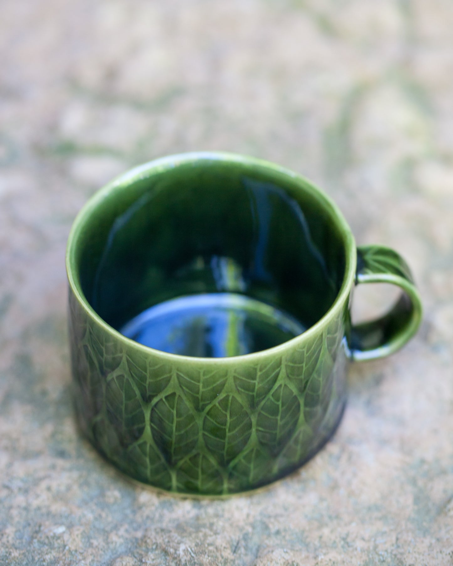 Kavlad kopp med lövmönster pinjegrön